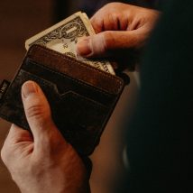 person getting 1 U.S. dollar banknote in wallet